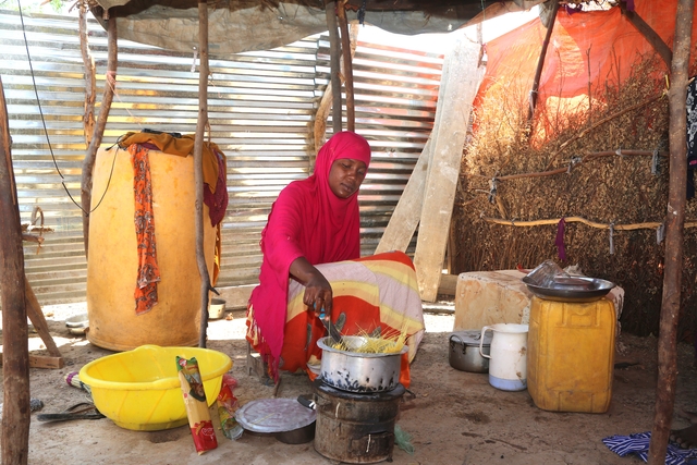 une femme africaine qui prépare son repas avec le bouillon cube maggi